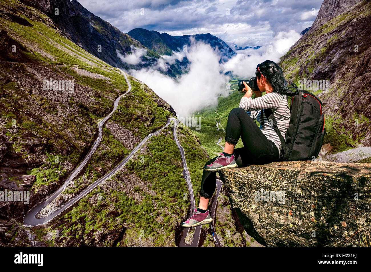 Photographe Nature touriste avec appareil photo shoots en se tenant sur le haut de la montagne. Chemin du troll ou Trollstigen Trollstigveien route sinueuse de montagne Banque D'Images