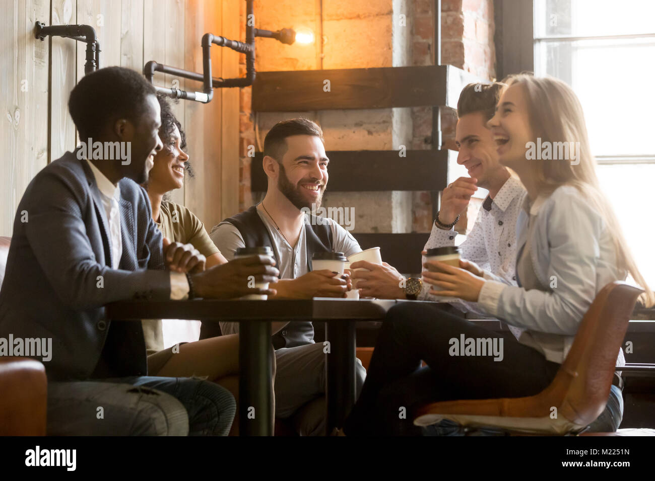 Jeunes amis multiraciale s'amusant rire boire du café dans Banque D'Images