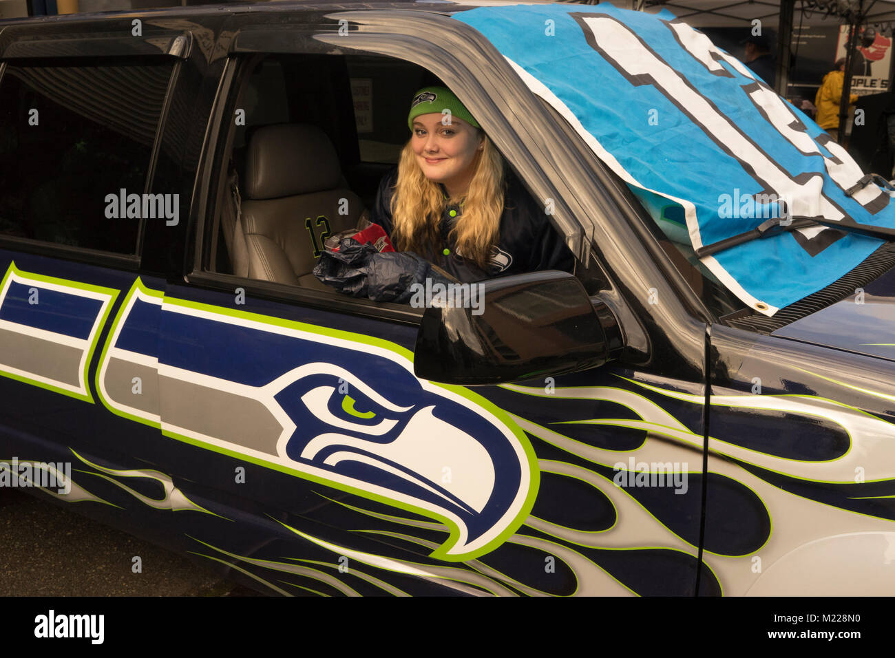États-unis, Washington, Seattle Seahawks fan de football, assise dans une voiture avec festuned les Seahawks logo. Banque D'Images
