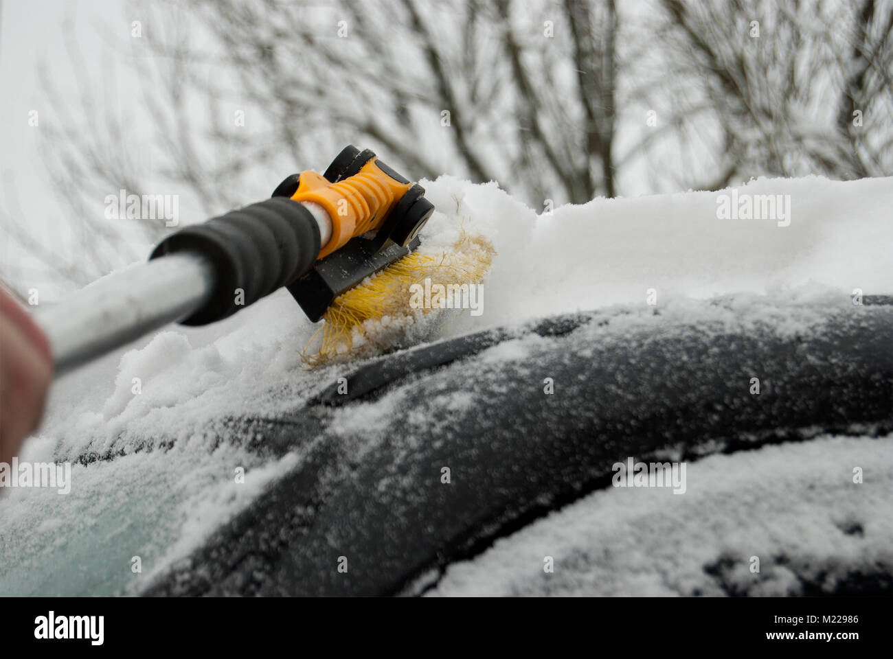 Nettoyage du toit de la voiture de la neige. Conséquences de fortes chutes de neige. Banque D'Images