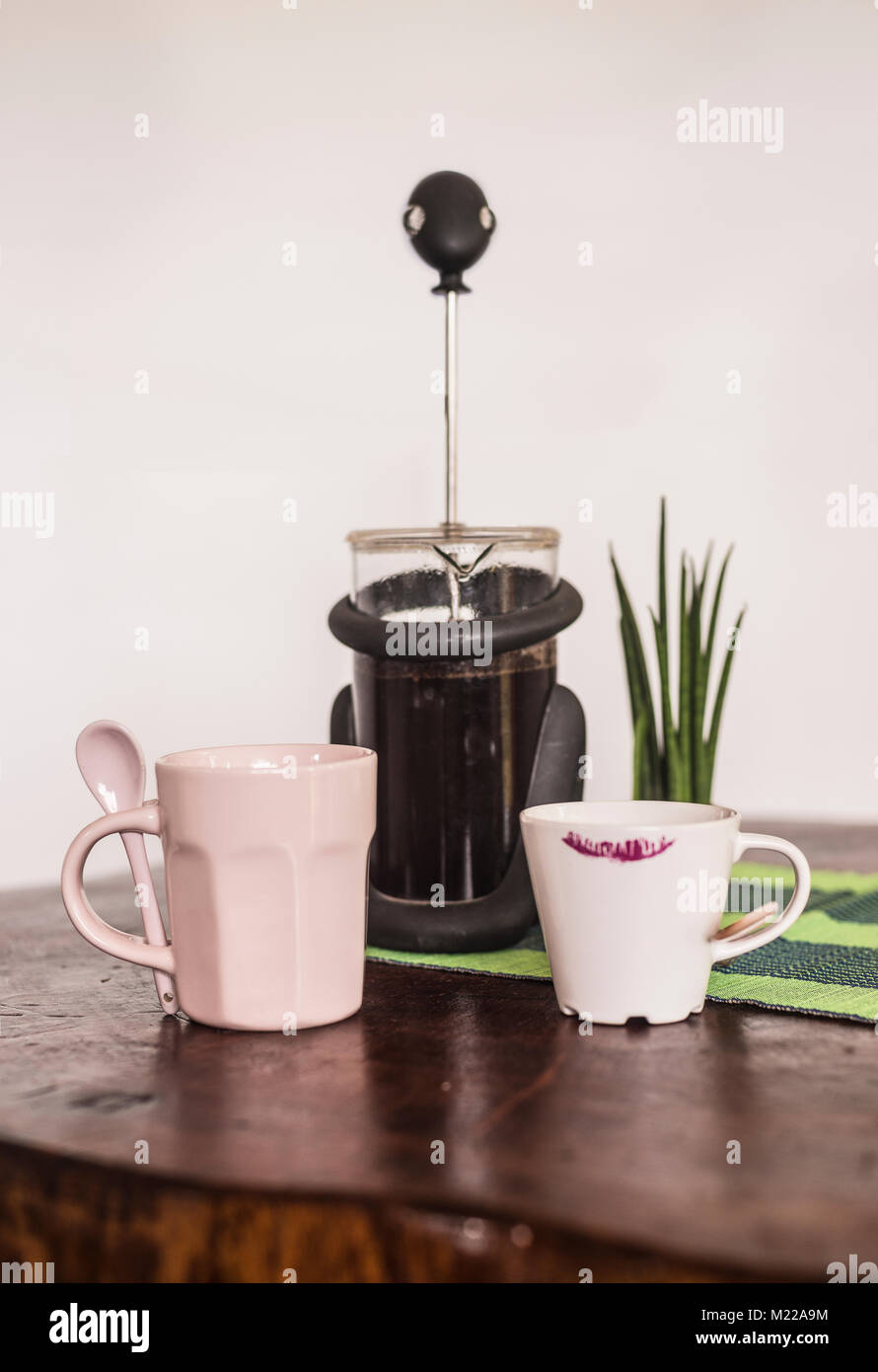 Presse française avec du café noir, et un mug et tasse de café sur une table en bois Banque D'Images