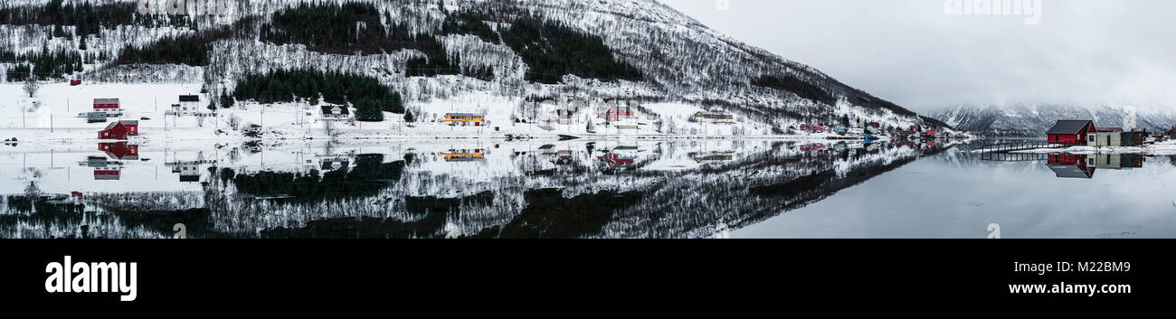 Réflexions de maisons dans l'eau parfaitement immobile d'une baie en Norvège Banque D'Images