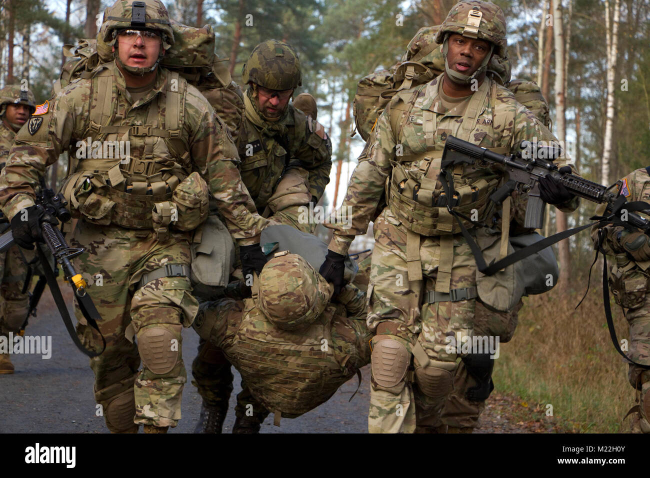 Une équipe de soldats du régiment de cavalerie 2d et 7e Brigade mécanisée de la Force terrestre tchèque, transporter une victime simulée à un point d'évacuation lors d'un épi de cavalerie ride 2 Novembre, 2017 dans le secteur d'entraînement Grafenwoehr, Allemagne. L'événement était organisé par le poste de commandement du régiment d'amener des équipes multinationales et echelon ensemble pour s'amuser un peu et de garder l'éperon ride tradition. Événements inclus un 12-mile ruck mars, le démontage et remontage des armes, traiter et d'évacuer un blessé, la navigation terrestre et CS chambre à gaz. Tous ceux qui ont participé à l'événement ont été attribué argent éperons. Banque D'Images