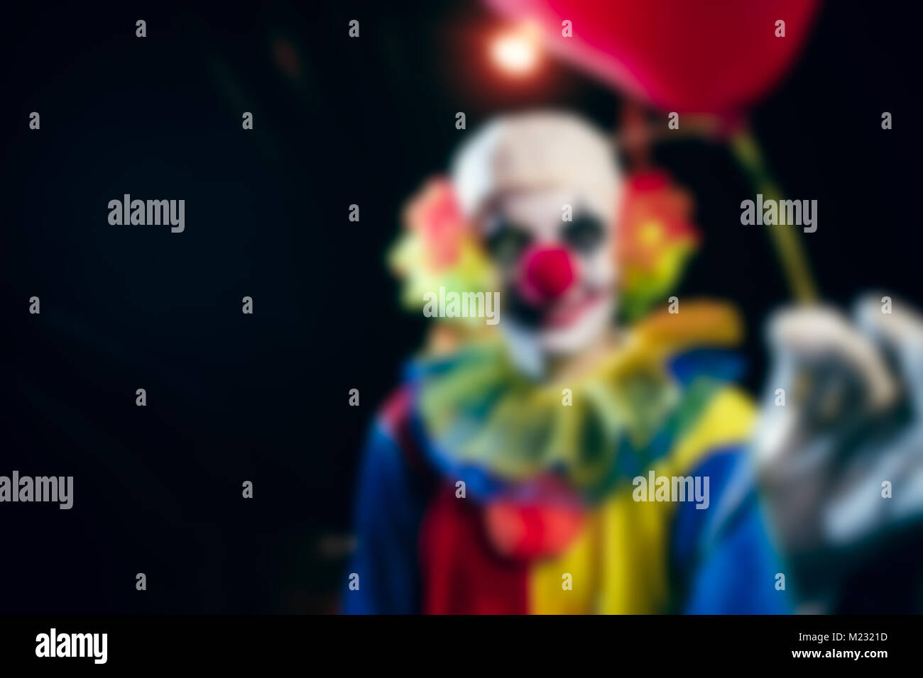 Photo floue de clown avec des ballons de nuit Banque D'Images