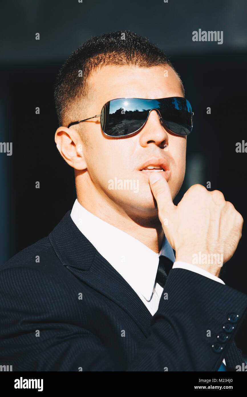 Bel homme en costume noir et lunettes de soleil. Agent secret, mafia,  bodyguard concept Photo Stock - Alamy