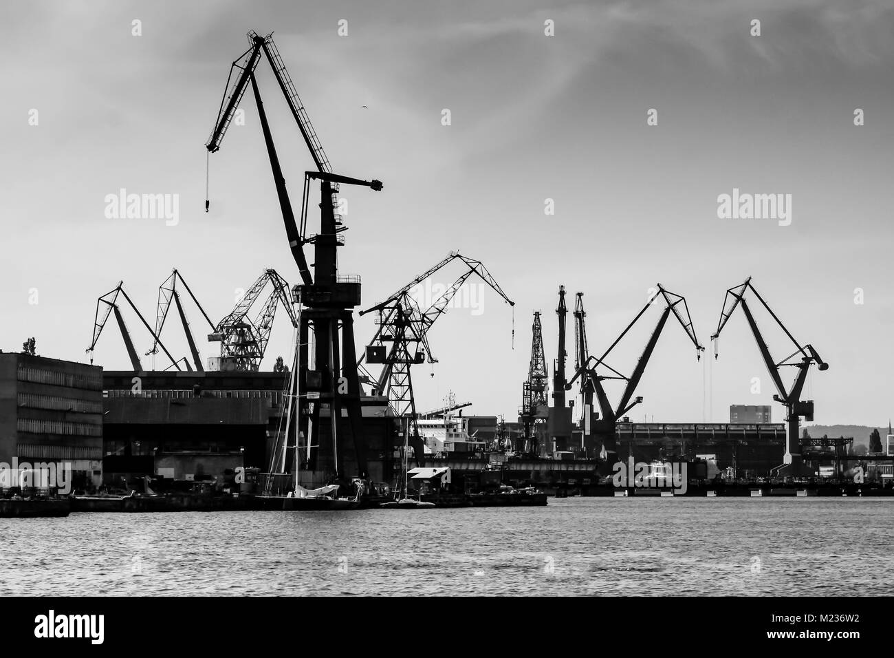 Chantier naval de Gdansk, Pologne. Style rétro noir et blanc. Des grues, des vieux bâtiments, chantier naval structures rouillées. Banque D'Images