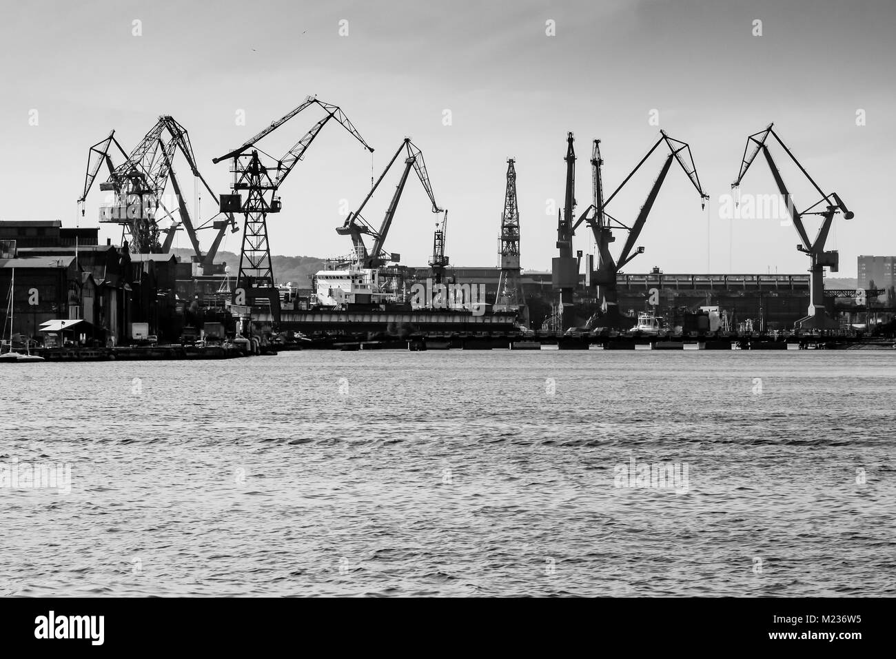 Chantier naval de Gdansk, Pologne. Style rétro noir et blanc. Des grues, des vieux bâtiments, chantier naval structures rouillées. Banque D'Images