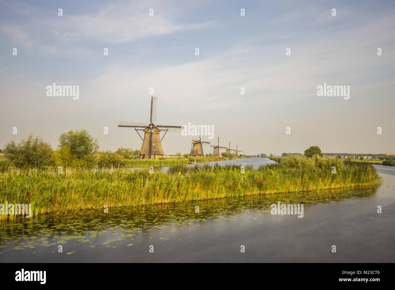 Moulins à vent de Kinderdijk, un site du patrimoine mondial de l'UNESCO, sont alignés au bord de l'eau en basse lumière du soir. Outre les moulins à vent, le site présente divers Banque D'Images