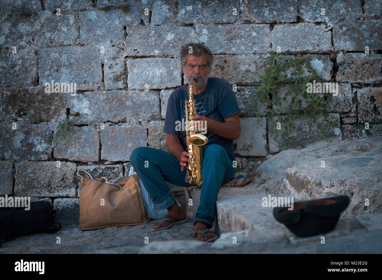 Saxophoniste à côté du mur de la forteresse Banque D'Images