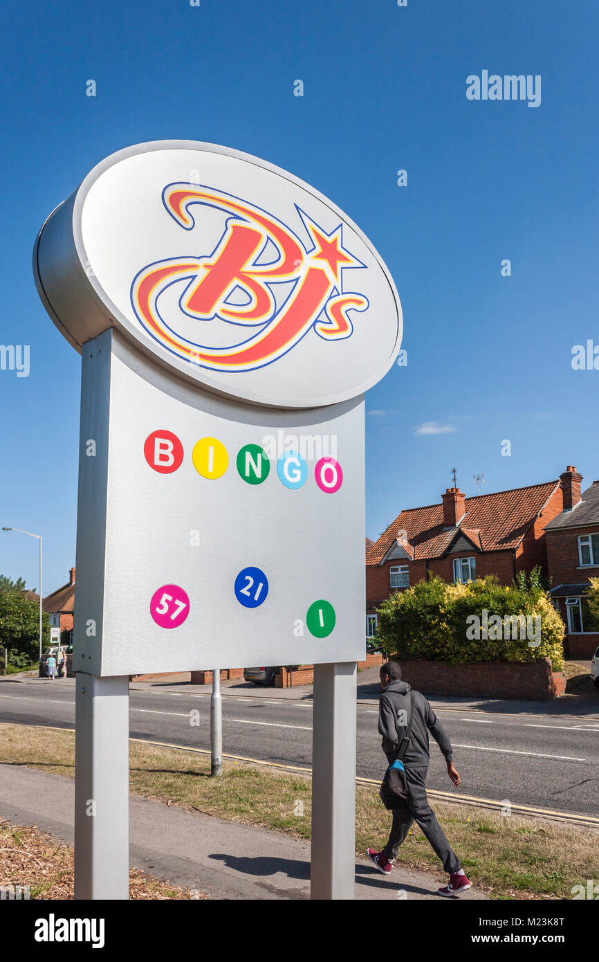 Jeune homme marche dernières signe sur l'extérieur de la rue entrée de BJs salle de Bingo Banque D'Images