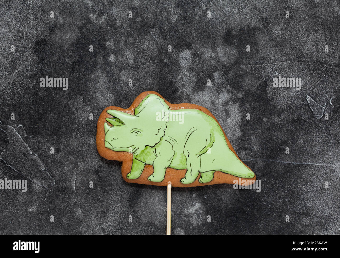 Gingerbread cookie fait maison en forme de dinosaure vert sur un fond de bois. L'espace pour texte et mise au point sélective. Banque D'Images
