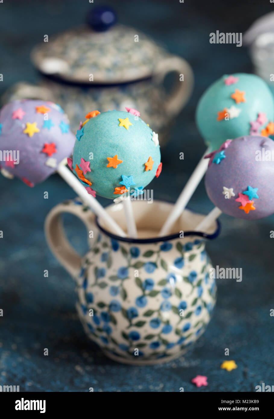 Des сolorful Cake pops avec des étoiles sur un fond en bois bleu, selective focus Banque D'Images
