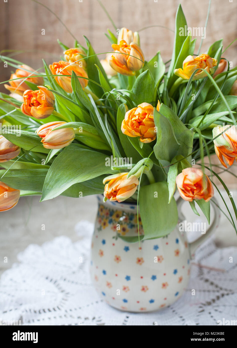 Un bouquet de tulipes orange fleurs dans un pot en céramique. De style rustique, selective focus Banque D'Images