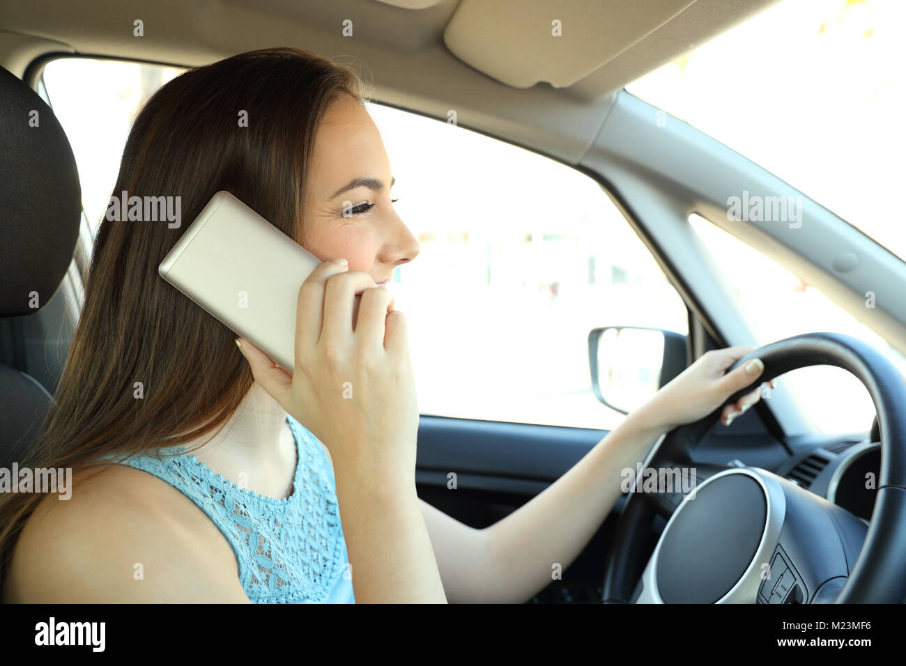 Vue latérale du portrait d'un conducteur distrait sur le téléphone appelant à la conduite d'une voiture Banque D'Images
