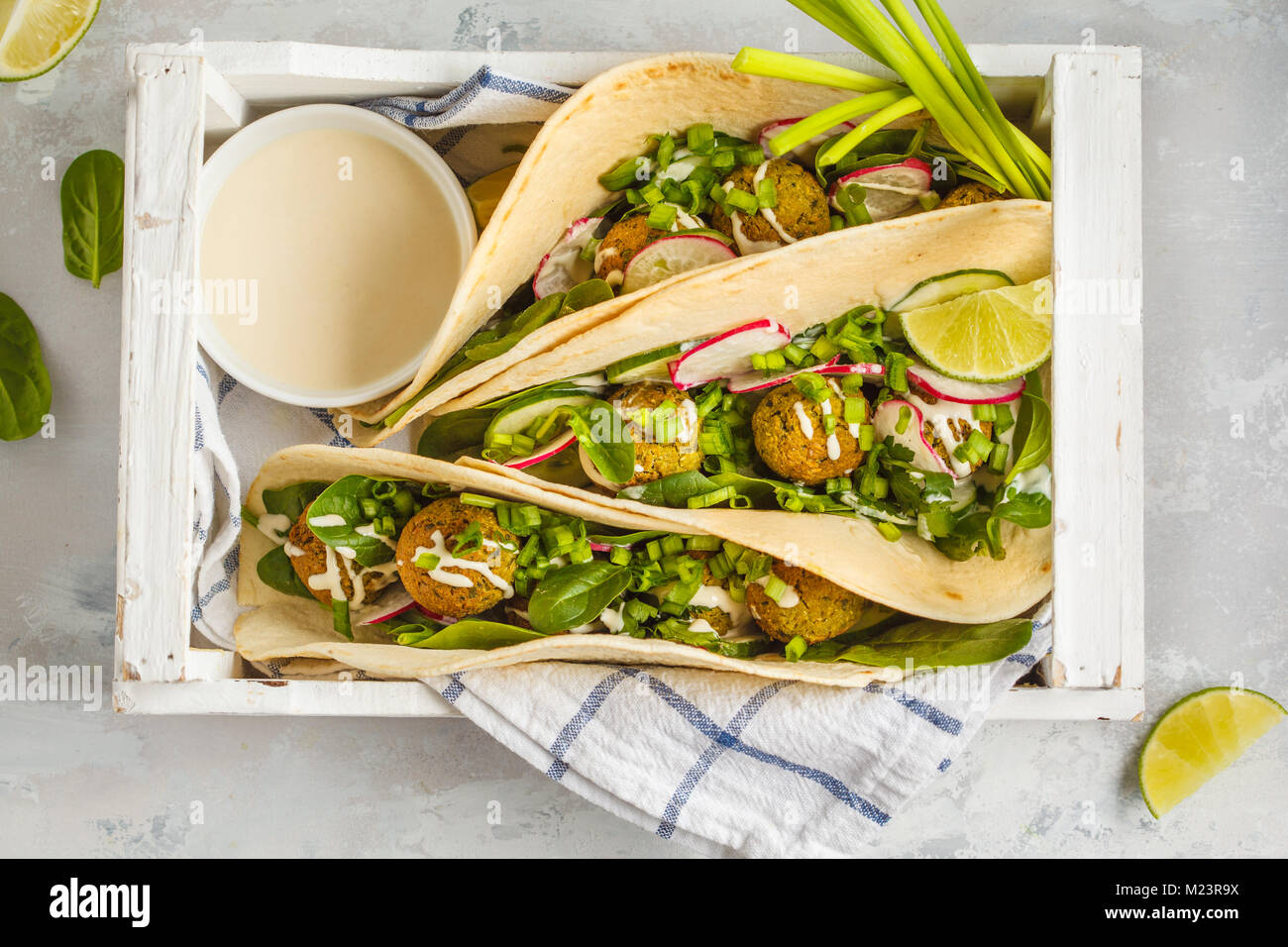 Falafels végétaliens avec légumes et sauce tahini dans la tortilla dans une boîte en bois blanc pour un pique-nique. Vegan aliments sains, l'Arabe de la nourriture. Banque D'Images
