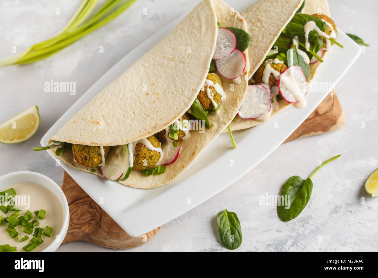 Falafels végétaliens avec légumes et sauce tahini tortilla dans sur un plat blanc. Vegan aliments sains Banque D'Images