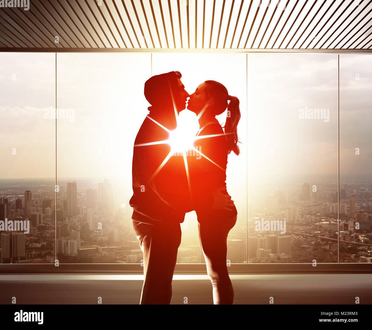 Couple de jeunes amoureux embrasser et baiser les uns les autres au coucher du soleil Banque D'Images