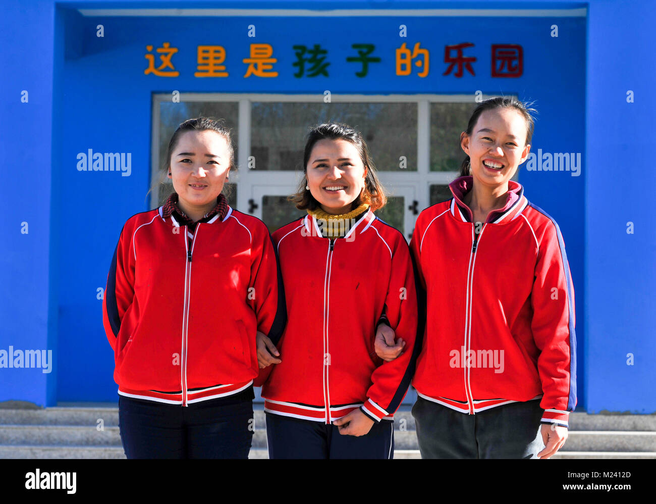 (180204) -- BEIJING, 4 février 2018 (Xinhua) -- Trois enseignants d'une école maternelle publique nouvellement construit de poser pour les photos avant le bâtiment de l'école dans Gaimai Village de Yining County, nord-ouest de la Chine, la Région autonome du Xinjiang Uygur, Novembre 22, 2017. Le jardin de 800 mètres carrés peut accueillir plus de 300 enfants du village, il offre gratuitement au long de l'éducation avec des aliments et boissons. Yuanmin Li, un délégué à la 19e Congrès national du Parti communiste chinois (PCC), a servi comme secrétaire du parti du village. Elle a mis beaucoup d'efforts dans la propagation de la partie de la ligne directrice a route Banque D'Images