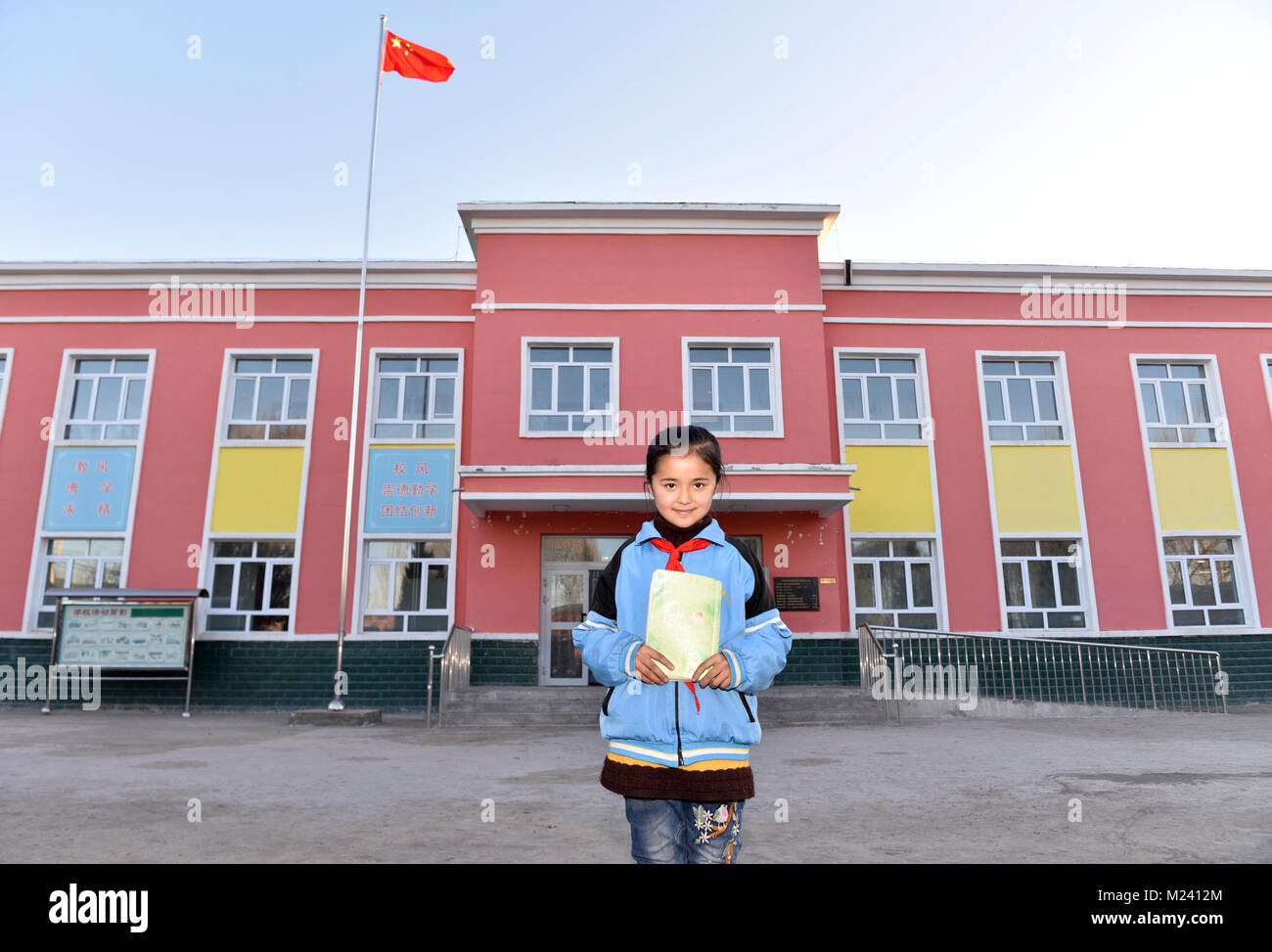 (180204) -- BEIJING, 4 février 2018 (Xinhua) -- une jeune fille de la classe 3, 2 e année d'une école primaire du village pose pour photos avant le bâtiment de l'école dans Gaimai Village de Yining County, nord-ouest de la Chine, la Région autonome du Xinjiang Uygur, Novembre 22, 2017. Elle et ses camarades apprécié la nouvelle salle de classe qui a été terminé à la fin de 2015. Elle voulait devenir médecin dans l'avenir, de servir sa ville natale. Yuanmin Li, un délégué à la 19e Congrès national du Parti communiste chinois (PCC), a servi comme secrétaire du parti du village. Elle a mis beaucoup d'efforts dans la propagation, la route, parti Banque D'Images