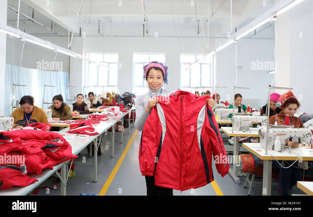 (180204) -- BEIJING, 4 février 2018 (Xinhua) -- un villageois démontre un manteau à un atelier textile dans Gaimai Village de Yining County, nord-ouest de la Chine, la Région autonome du Xinjiang Uygur, Novembre 22, 2017. Après 3 mois de formation, elle et son mari s'est joint à la petite usine pour gagner sa vie, sans quitter le village. Yuanmin Li, un délégué à la 19e Congrès national du Parti communiste chinois (PCC), a servi comme secrétaire du parti du village. Elle a mis beaucoup d'efforts dans la propagation, la route, parti politique et ligne directrice aux gens dans le village, après son retour de congrès du parti. Banque D'Images