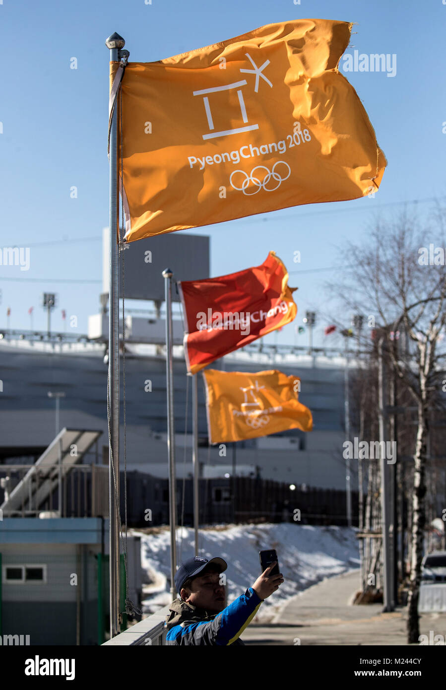 Pyeongchang, Corée du Sud. 4e Mar, 2018. Un homme prend un avec l'hiver selfies drapeaux olympique dans l'arrière-plan à Pyeongchang, Corée du Sud, 4 février 2018. Jeux Olympiques d'hiver de Pyeongchang 2018 ont lieu du 9 au 25 février. Crédit : Michael Kappeler/dpa/Alamy Live News Banque D'Images