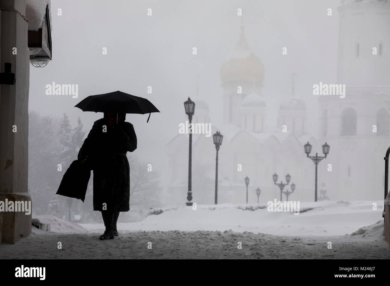 Moscou, Russie - 4 Février, 2018 : une femme avec un parapluie passer à travers les portes de la tour Spassky du Kremlin de Moscou durant une chute de neige dans la région de Moscou, Russie Crédit : Nikolay Vinokourov/Alamy Live News Banque D'Images