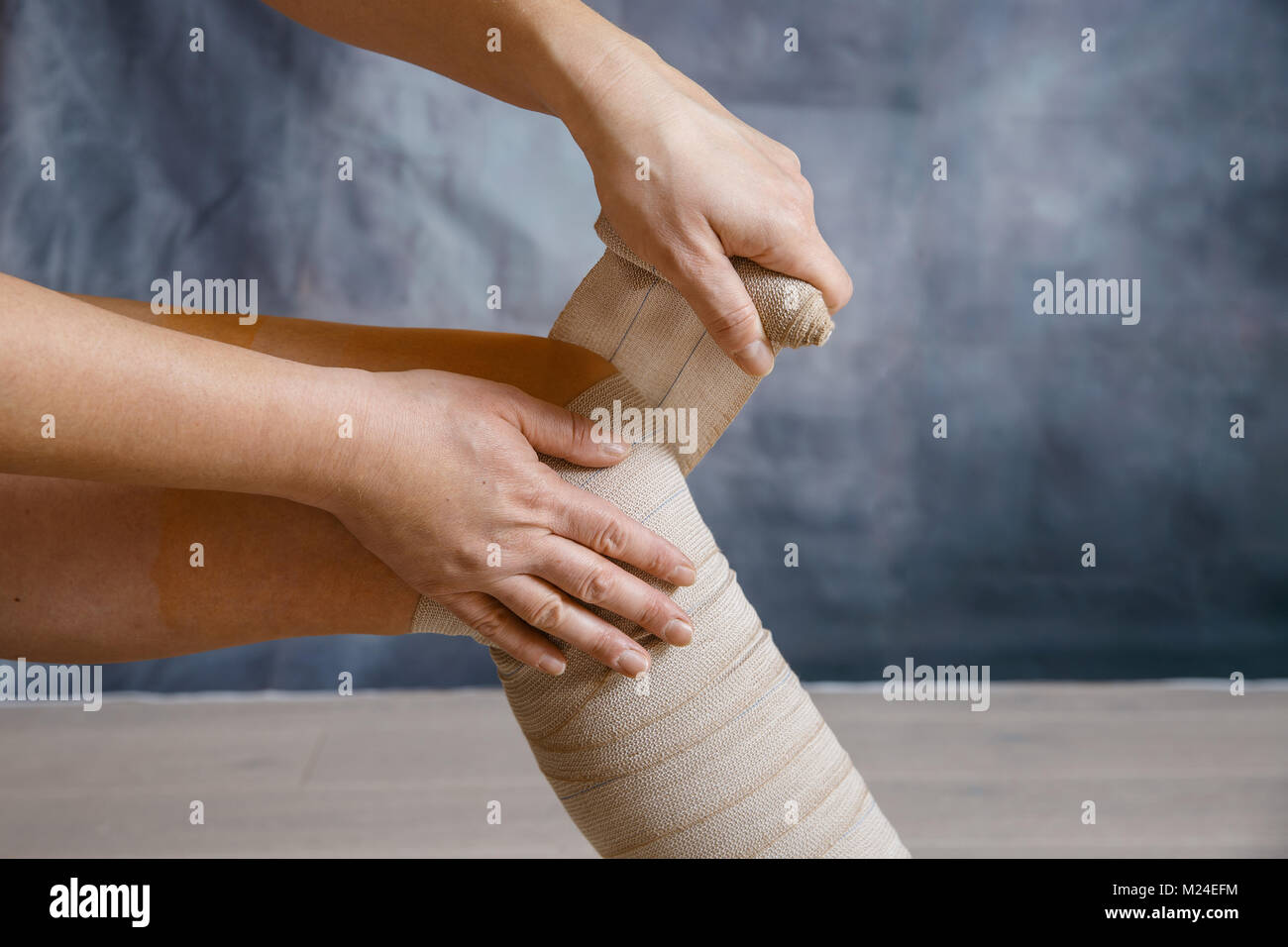 Femme patient avec varices application bande de compression élastique après la chirurgie. Le traitement curatif, la prévention de la thrombose et de soins de santé senior Banque D'Images