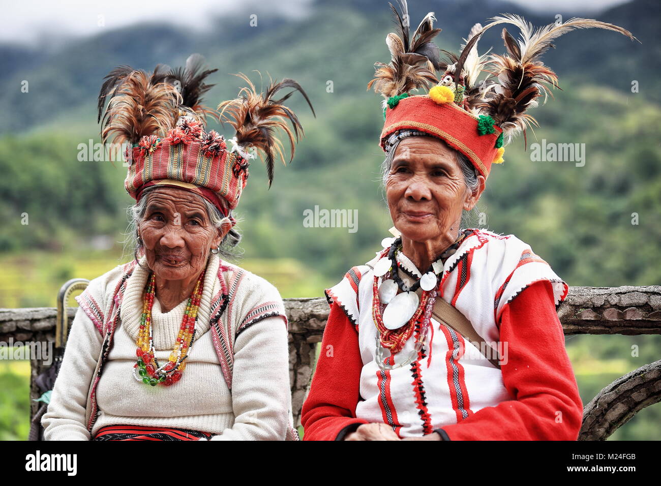 Banaue, Philippines-October 8, 2016 : Certaines personnes âgées Ifugaos -hommes et femmes- robe encore dans leurs costumes traditionnels et la coiffure en position assise par le r Banque D'Images