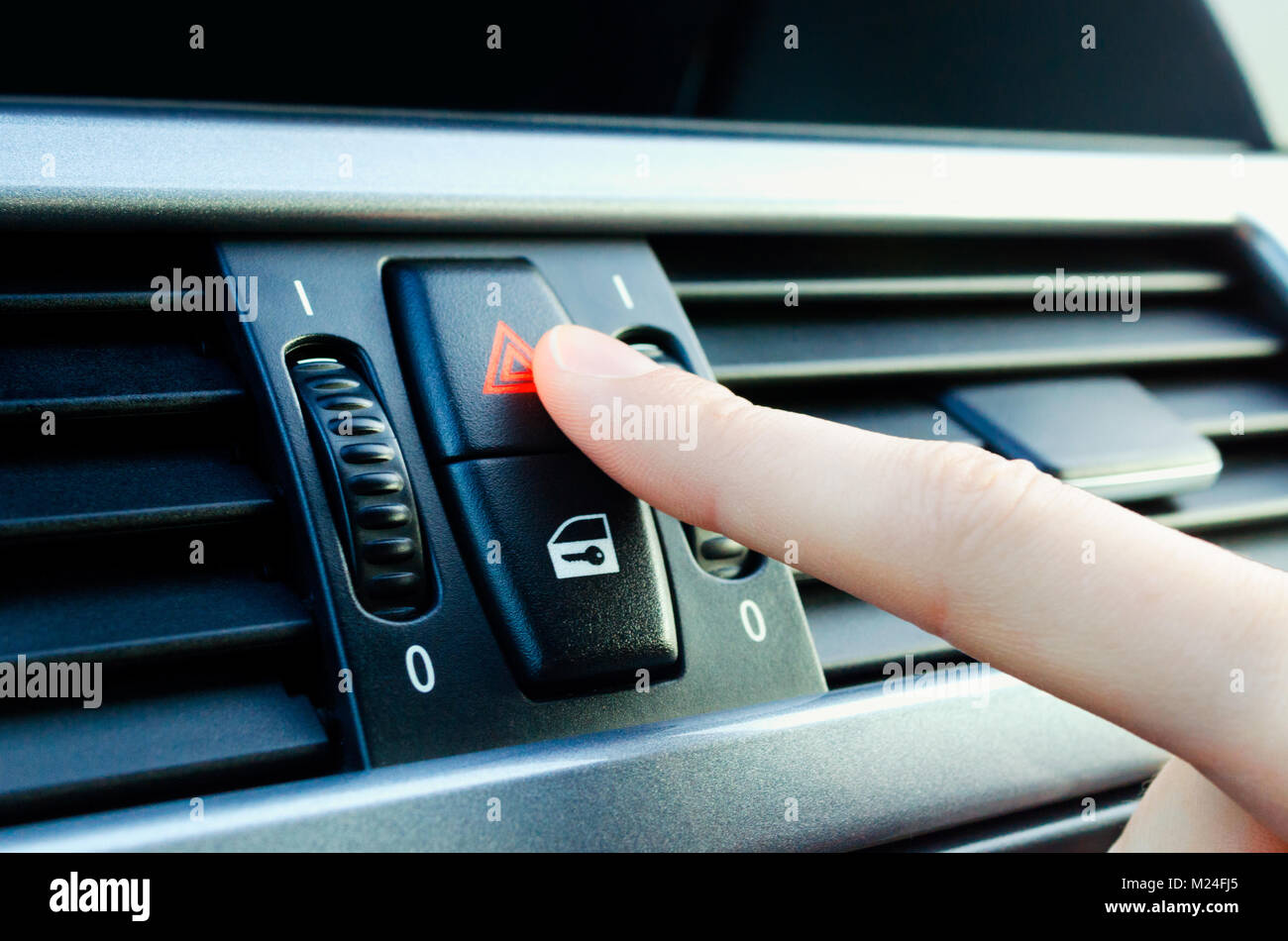 La main de l'homme tournant sur le bouton d'éclairage d'urgence voiture Banque D'Images