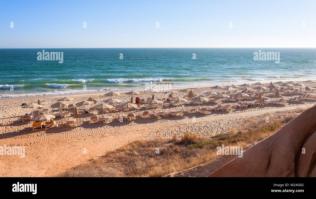 Des chaises longues et des parasols sur la plage de Falesia au soleil de l'après-midi, Algarve, Portugal Banque D'Images