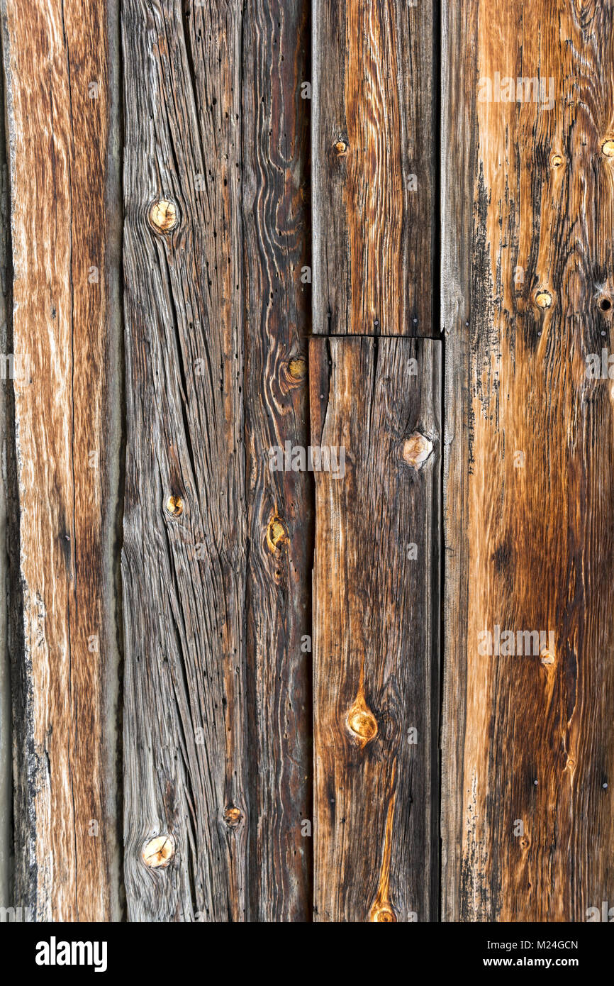 Gros plan d'une texture rustique en bois avec des planches de bois vieillies. La surface révèle les motifs naturels du grain, les nœuds et les lignes altérées. Banque D'Images