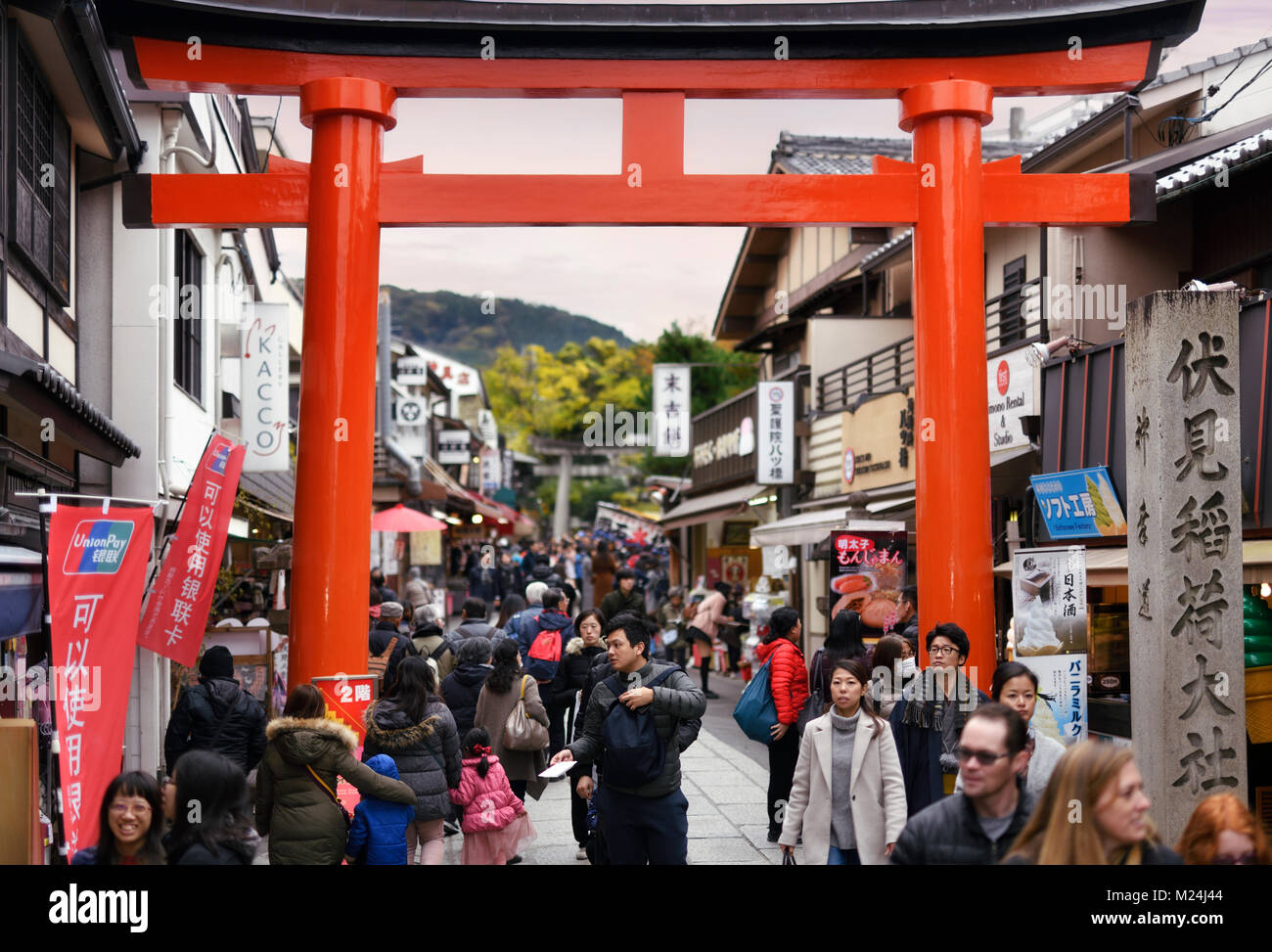 Les gens qui passent par l'intermédiaire d'un torii rouge à la sortie de Fushimi Inari Taisha au sanctuaire Shinto Fushimi ward, Kyoto, Japon 2017 Banque D'Images