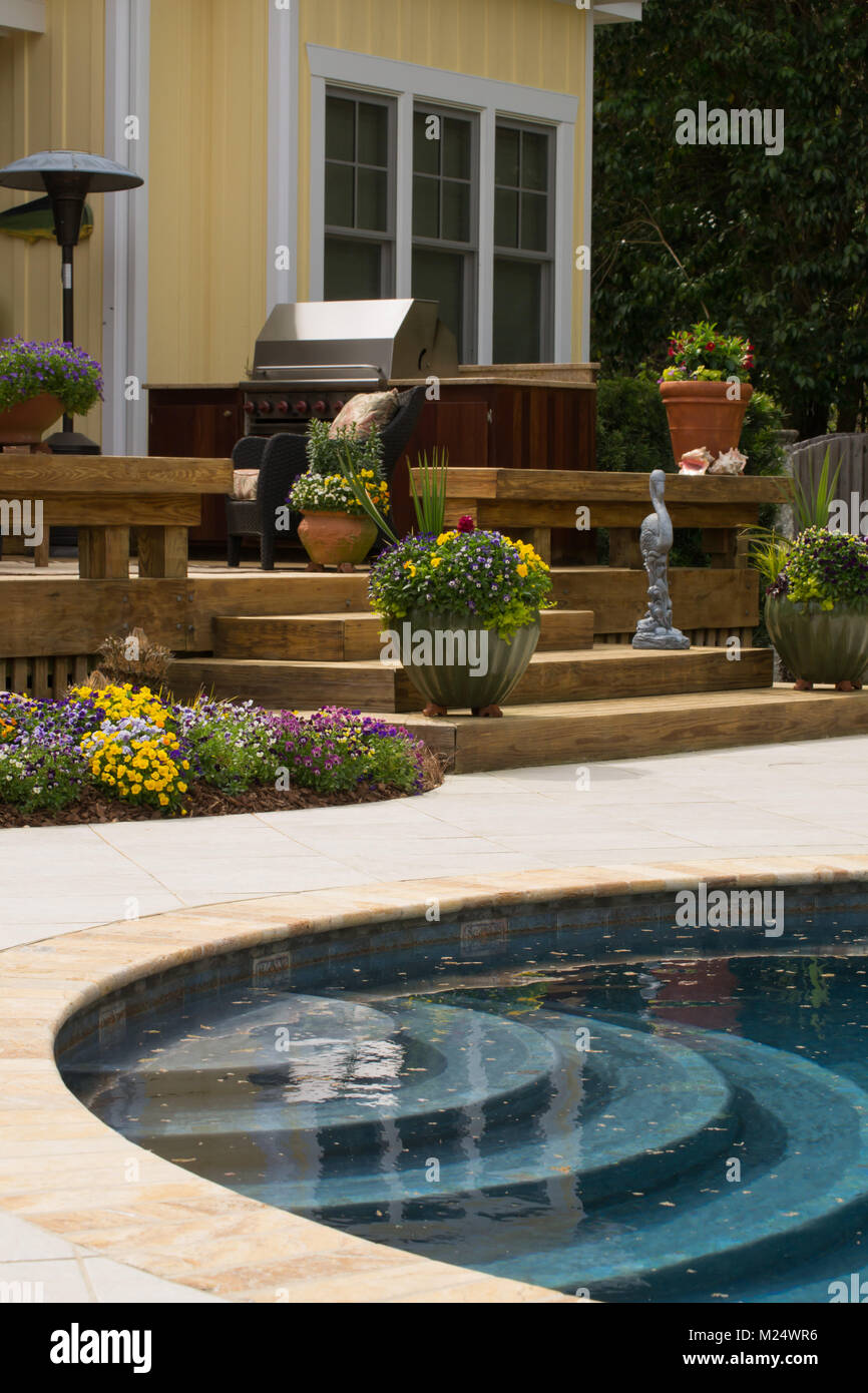 Paysage et paves jardin design avec blue piscine étincelante et pont décoratif Banque D'Images
