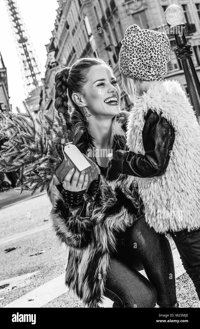 L'hiver à la mode chaud bouillant à Paris. smiling mother and daughter moderne avec arbre de Noël à Paris, France à l'un l'autre Banque D'Images