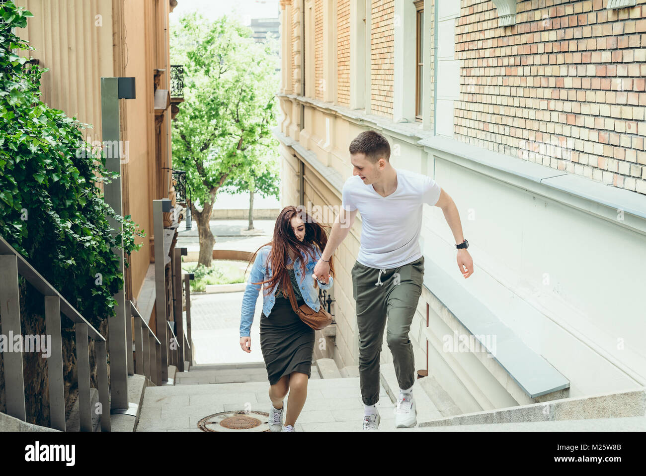 Close-up portrait du jeune joli couple d'amoureux se tenant la main en montant les escaliers dans l'étroite rue de Budapest en Hongrie. Banque D'Images