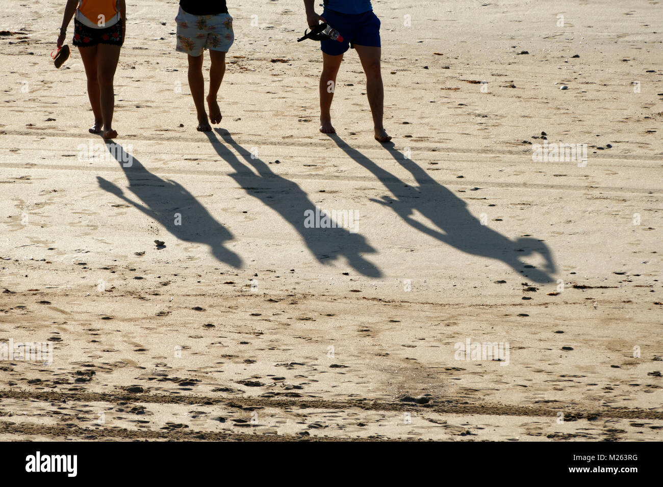 Silhouette de 3 personnes marchant sur une plage de sable fin, Cable Beach, Broome, Australie occidentale, Kimberley Ouest Banque D'Images