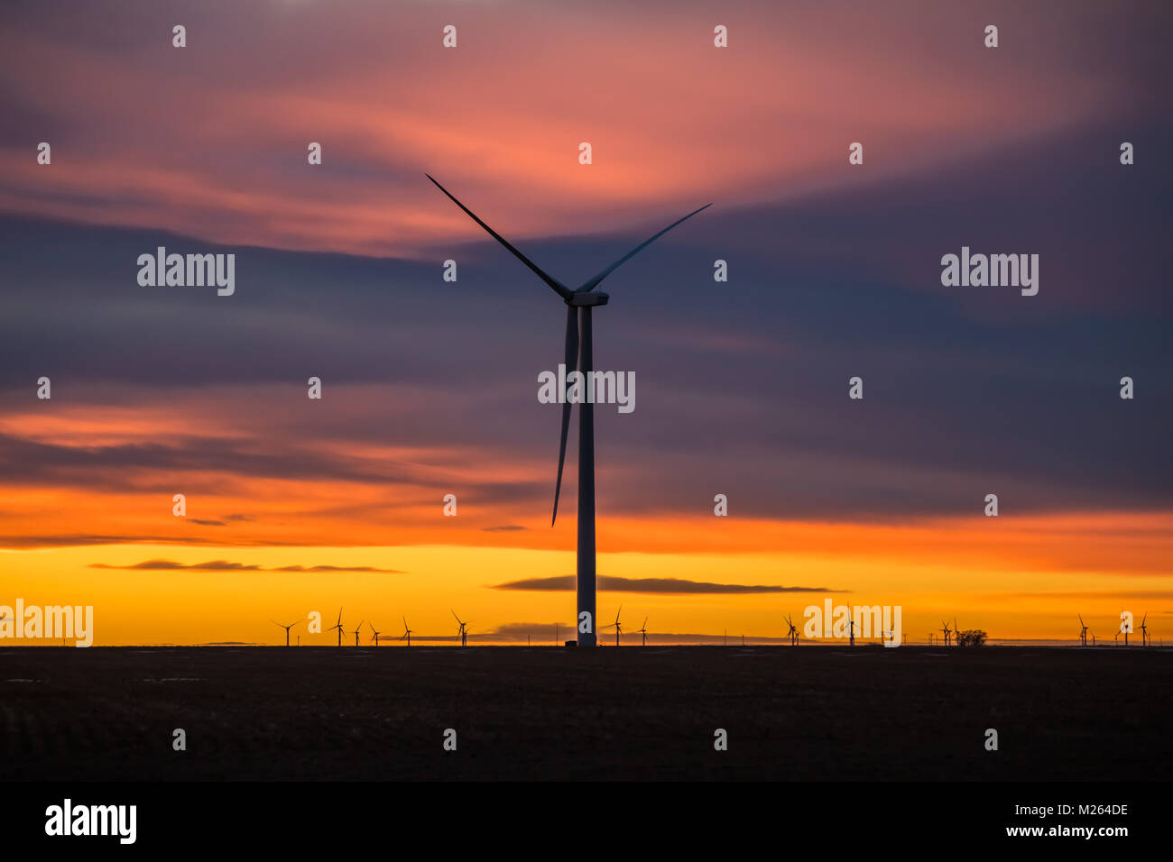 De soleil colorés avec des silhouettes de moulins à vent en premier plan ; Colorado, États-Unis Banque D'Images