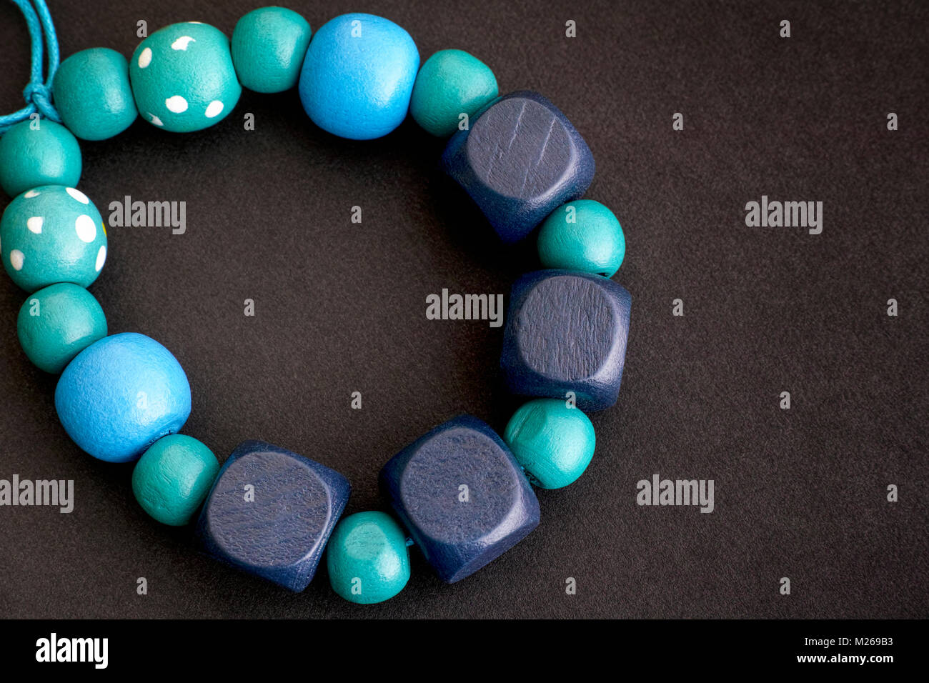 Bracelet de perles en bois bleu sur fond noir. Close-up. Banque D'Images