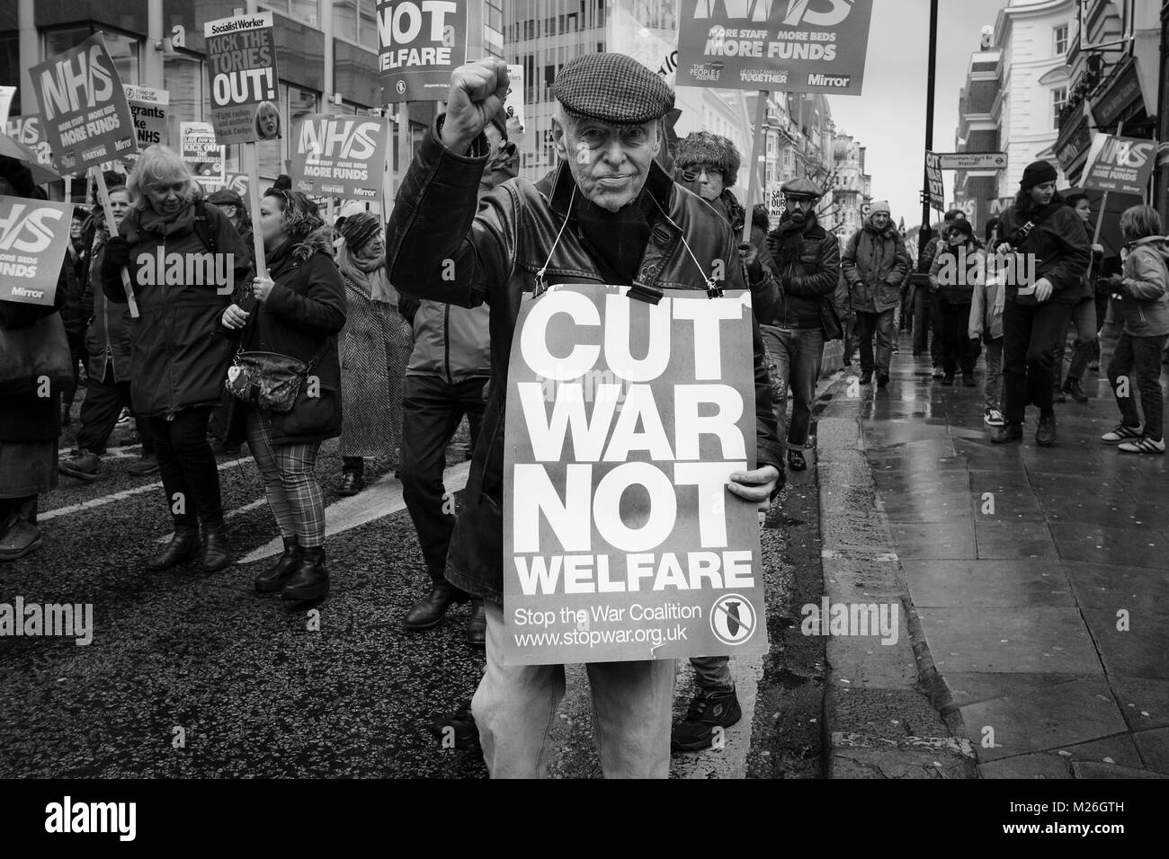 Photographie en noir et blanc à Londres : un homme plus âgé est en marche pour protester contre le NHS contre les réductions de financement du gouvernement britannique. Banque D'Images
