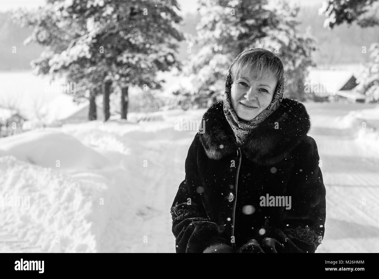 Le noir et blanc portrait de jeune femme russe dans l'hiver sur le village enneigé. Banque D'Images
