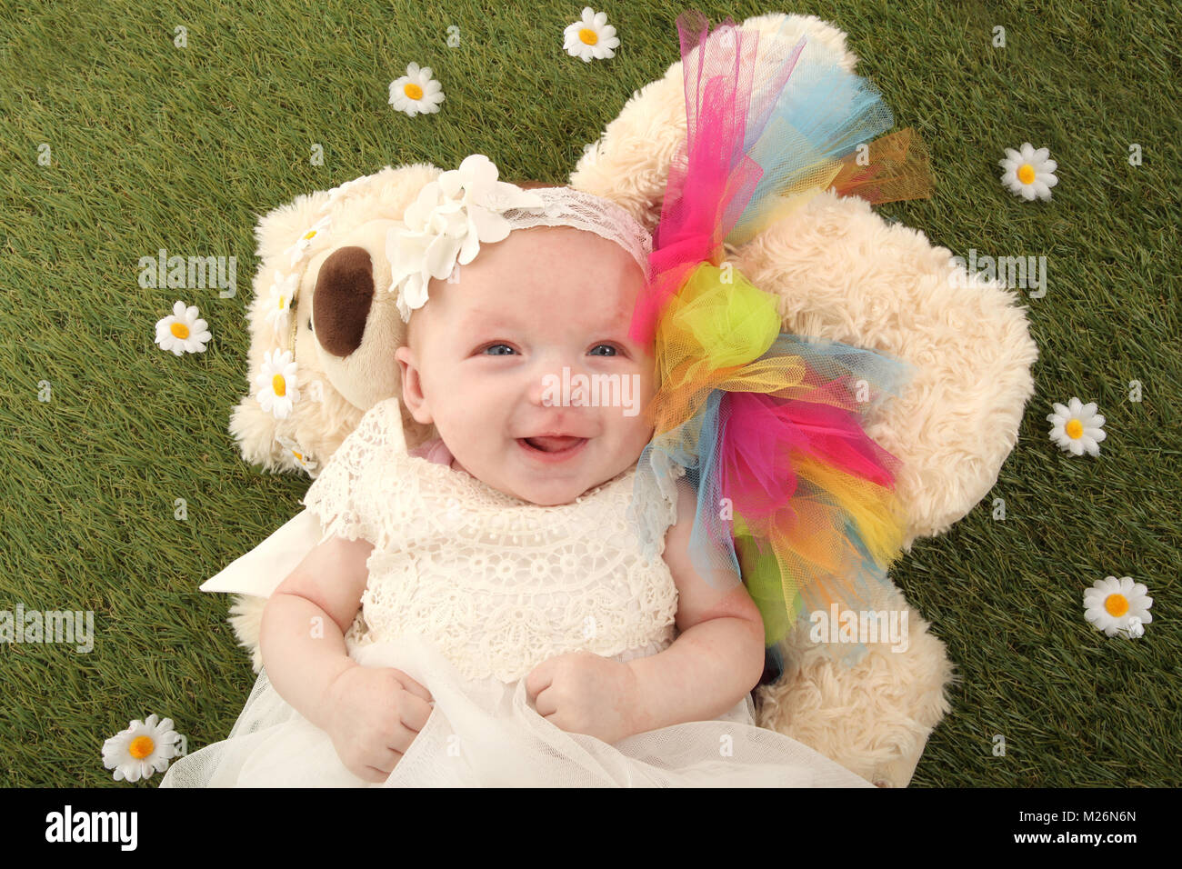 Petite fille de 11 semaines avec teddy dans le jardin Banque D'Images