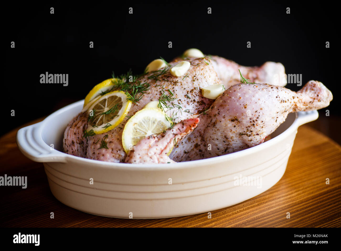 Le poulet cru mariné aux épices dans un plat allant au four Banque D'Images