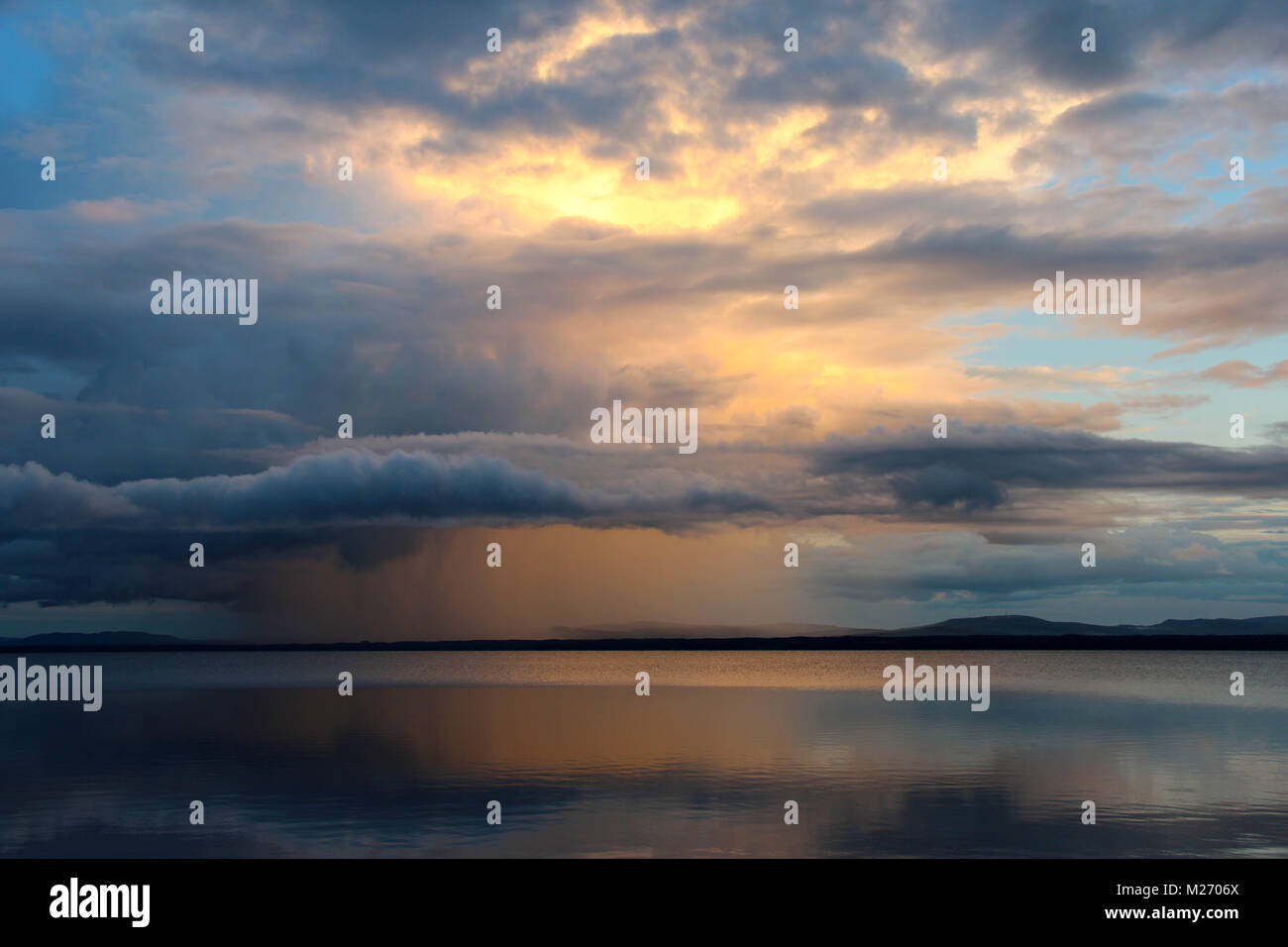Coucher du soleil avec des nuages et pluie nuages sur le lac d'ORSA, Orsa, dalarna, Suède. Banque D'Images