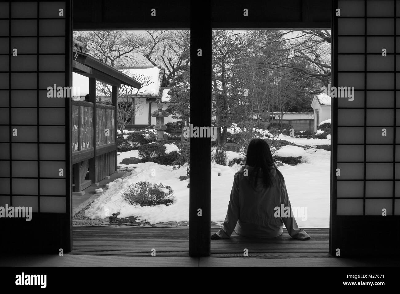Abstract image en noir et blanc de lonely woman sitting vous détendre sur la terrasse en bois et à l'avant à l'extérieur du parc japonais de Kawagoe, Japon. Château Banque D'Images