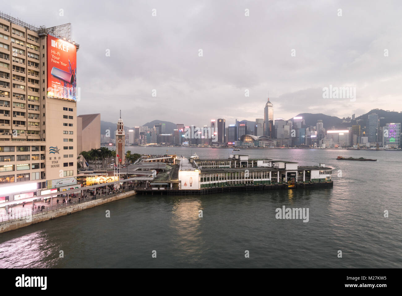 Hong Kong - Le 25 janvier 2018 : Le Star Ferry terminal à Tsim Sha Tsui à Kowloon, l'ancienne tour de l'horloge et la célèbre île de Hong Kong skyline at sunse Banque D'Images