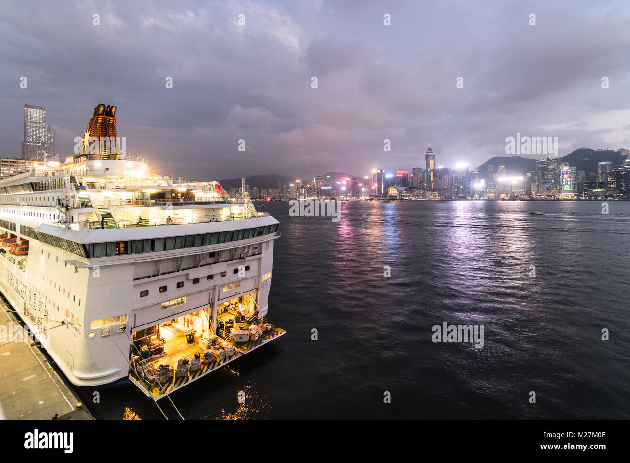 Hong Kong - Le 25 janvier 2018 : un grand bateau de croisière ancrés à l'Ocean Terminal de croisière à Kowloon avec l'île de Hong Kong skyline célèbre dans le dos Banque D'Images