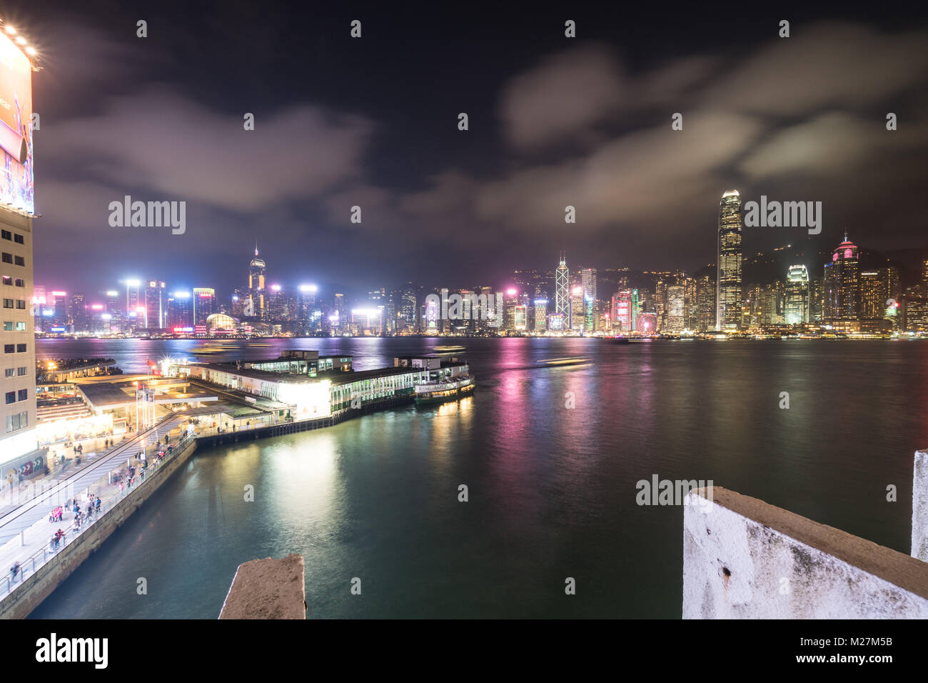 Hong Kong - Le 25 janvier 2018 : Le Star Ferry terminal à Tsim Sha Tsui à Kowloon avec la célèbre île de Hong Kong skyline at night sur le Victoria h Banque D'Images