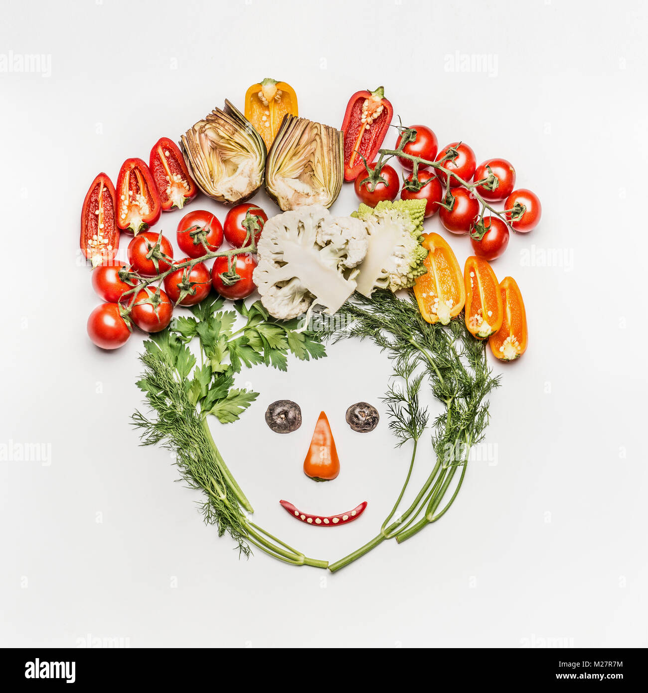 Drôle de visage faites de différents légumes frais sur fond blanc, vue du dessus. Nettoyer en bonne santé alimentaires, les régimes végétariens ou repas food concept Banque D'Images