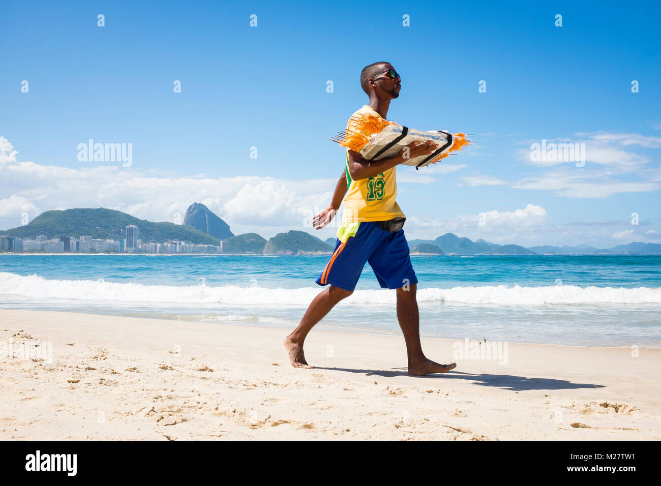 RIO DE JANEIRO - le 21 mars 2017 : Vendeur de plage à pied le long de la plage de Copacabana la vente de crevettes grillées Banque D'Images