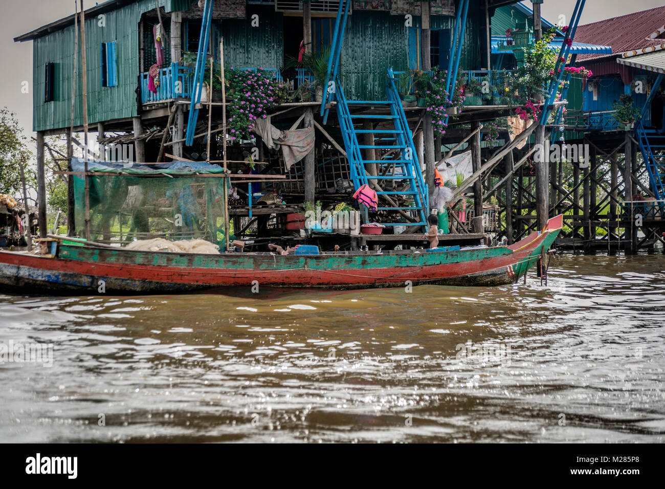 Bateau de pêche et maison sur pilotis, Kampong Phluk village flottant, la Province de Siem Reap, au Cambodge. Banque D'Images